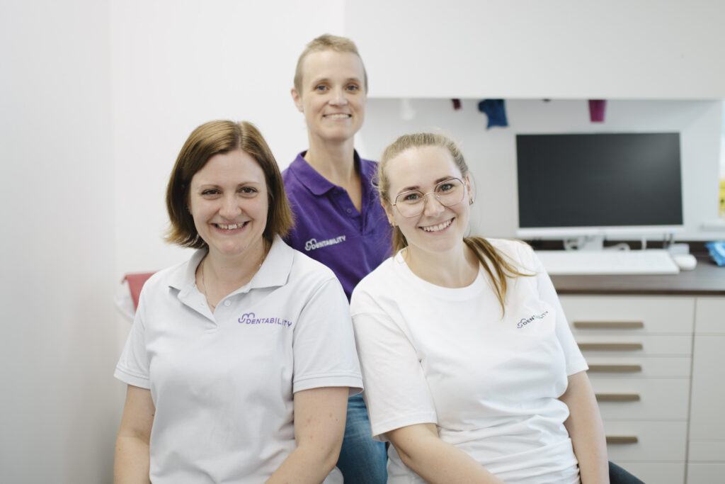 Das Dentability-Team – Annette Buck, Dr. Ann-Kathrin Arp und Jennifer Wetendorf – lächelnd in der Zahnarztpraxis